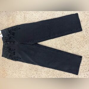 Dark blue denim jeans with a bit f a floral pattern.